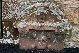 Bedrule Church, Graveyard
I8th century round headed grave-stone with angel situated at the top above skull and crossbones surrounded by two pillars. Appears to be against a wall and partially buried in tarmac.