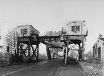 General view from E of E end of bridge, showing two towers supporting control cabins (with connecting overhead gantry) and in centre, rolling/lifting span