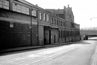 View from NW showing part of WSW front (Rigby Street front) of works with bridge in background