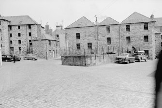 View from WSW showing WSW front of lower city mills with town's lade in foreground and granary and numbers 60-59 in background