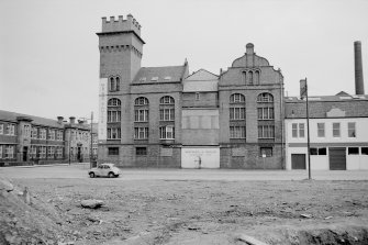 View from W showing WNW front of grain mills, Glasgow with part of dyeworks and paint factory on right and school on left