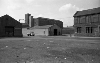 View from SE showing SSW and ESE fronts of numbers 89-93 French Street with part of Barrowfield Weaving Factory on right and Barrowfield Spinning Factory in background