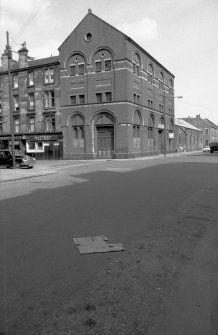 View from W showing WNW and SSW fronts of depot with part of tenements on left