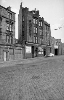 View from W showing WSW front of tenement and office with warehouse on right