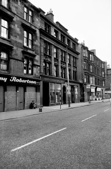 View from E showing NNE front of press building with tenements in background and part of numbers 571-575 in foreground