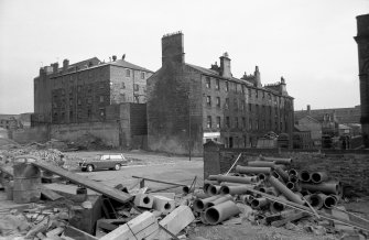 View from NNW showing NNE front and part of WNW front of tenements with N block of mill on left