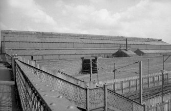 View looking E from footbridge showing part of WSW front of Mons shops