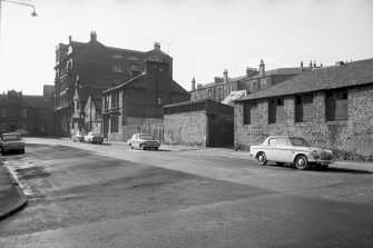 View from N showing ENE front of stationery works and numbers 22-16 with part of stables in foreground and offices in background