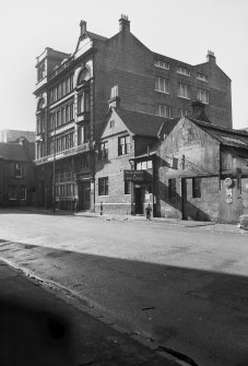 View from N showing ENE front of stationery works with part of numbers 22-16 in foreground