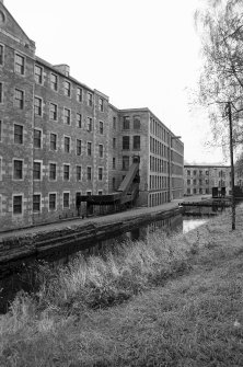 View from E showing NNE and ESE fronts of Mill Number 2 with part of Mill Number 3 on left, Mill Number 1 in background and lade in foreground