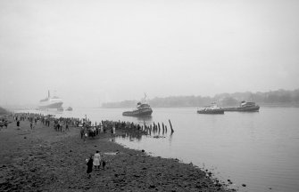 View looking SE showing QE II on River Clyde approaching Bowling with remains of pier in foreground