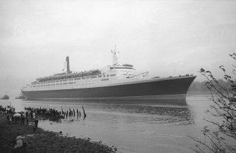 View looking SE showing QE II on River Clyde approaching Bowling with remains of pier in foreground