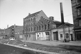 View from SSW showing WSW front of wire weaving factory with offices of Dock Engine and Boiler Works in background and cooperage in foreground