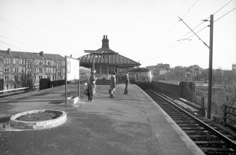 View from NW showing front of Pollokshaws East Station, Glasgow, with tenements behind.