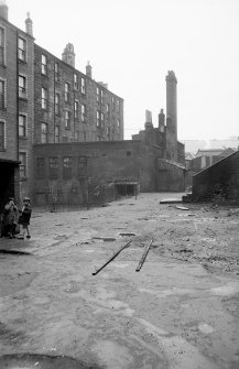 View from E showing ESE front and part of NNE front of workshop with part of tenements on left
