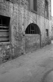 View from S showing bricked up arched doorway on ESE front