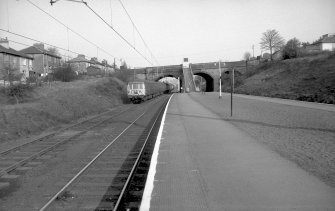 View from WNW showing train approaching station with bridge in background