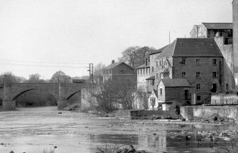 View from SSE showing part of SW and SE fronts of mill with part of bridge on left