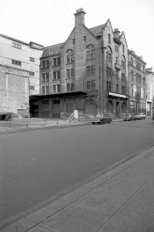 View from SSE showing ESE front and part of SSW front of warehouse with numbers 23-25 in background