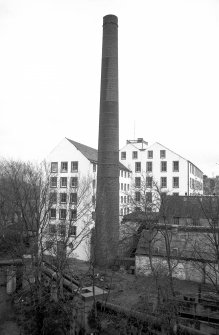 View from WNW showing chimney with part of 'Old End' on left, part of newer block in background and part of outbuildings on right