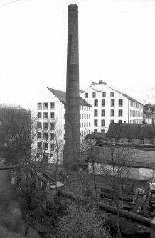 View from WNW showing chimney with part of 'Old End' on left, part of newer block in background and part of outbuildings on right