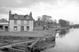 View from NNW showing NW front of building with house on left and canal basin in foreground