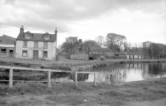 View from NW showing NW front of building with house on left and canal basin in foreground