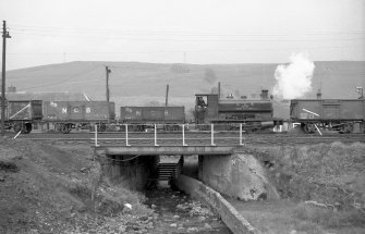 View from NNE showing trucks and NCB locomotive number 19 crossing bridge near washery
