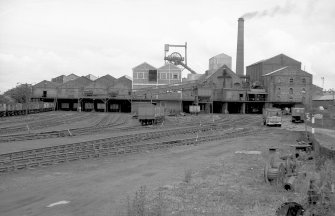 General view from S showing S front of old washer plant (right) with coal elevator shed and hopper, headgear, dense medium plant, pithead building and south elevator conveyor system on left