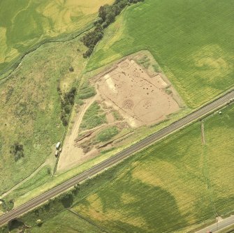 Oblique aerial view showing the excavation of a palisaded enclosure.