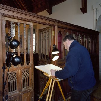Interior.  View of John Borland (Survey and Graphics) drawing traceried doors in rood screen.
Digital copy of E 26558 CN.


