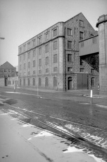 View from SE showing SSW front and part of ESE front of main building of flour mill with number 30 Waterloo Quay in background