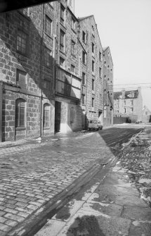 View from S showing part of ESE front of main building with brick extension of flour mills and tenement in background