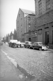 View from SW showing WNW front and part of SSW front of N block with part of S block in foreground and workshops in background