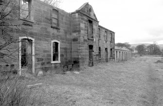 View from S showing remains of ESE front of stables with cottages in background