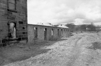 View from S showing remains of ESE front of cottages with part of stables on left