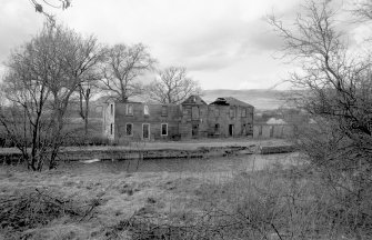 View from SE showing remains of SSW and ESE fronts of stables with cottage on right