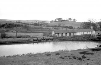 View from SSW showing S front of overflow with cottages on right