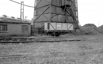 View from ENE showing part of SE and NE fronts of wooden cooling tower with wagon in foreground