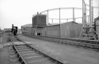 View from NW showing part of E gasholder with building in foreground