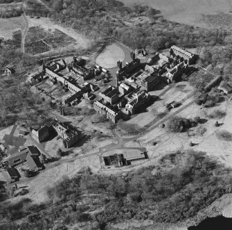 Oblique aerial view centred on the hospital, halls, nurses home, former mortuary, and workshops, taken from the SSE.