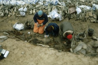 Excavating the boat burial. The skeletons and the whalebone plaque are visible.