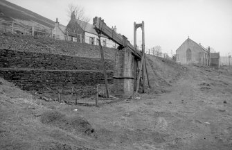 View from WNW showing NW and SW fronts of beam engine with part of cottages on left and church in background