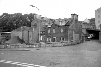 View from E showing ENE and SSE fronts of office with mill buildings in background