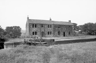 General view from S showing WSW and SSE fronts of lockeeper's house and stables with part of lock in foreground