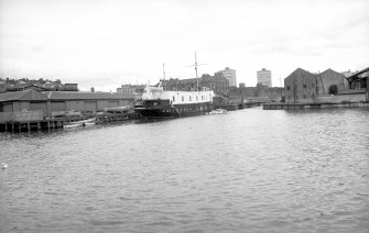 General view looking WSW showing Training Ship (TS) Dolphin beside entrance to dock with warehouse on right