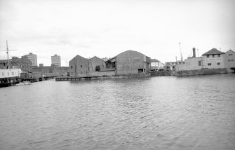General view looking W showing warehouse with entrance to dock on left and engineering works on right
