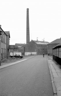 View looking NNE showing chimney and part of WSW and SSE fronts of weaving sheds