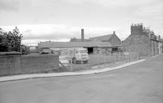 View from S showing part of SSE front of north-light weaving sheds of mill, with numbers 45-37 Panmure Street on right.