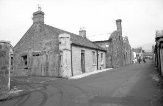 View from W showing WNW and SSW fronts of office (possible) with buildings in background